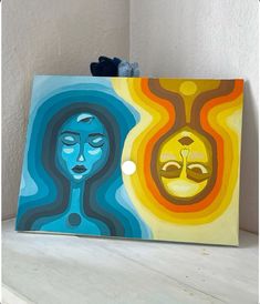 an art piece with two faces painted on it