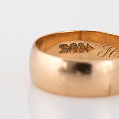 a gold wedding ring with the word love engraved on it's center and an arrow in the middle