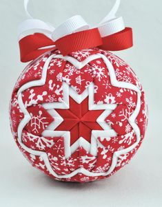 a red and white ornament with snowflakes on it's side