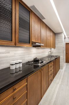 a kitchen with wooden cabinets and black counter tops on the bottom right hand corner is an instagram post that reads, we design studio follow