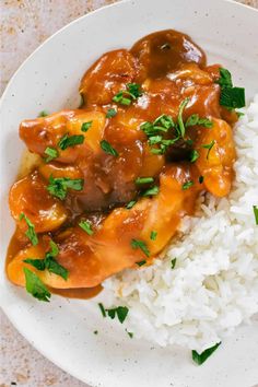 a white plate topped with rice and meat covered in gravy