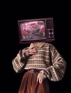 a woman wearing a sweater and skirt with a tv on her head over her head