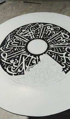 a white plate with some black and white designs on the inside, sitting on top of a table