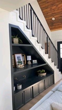 a living room filled with furniture under a stair case