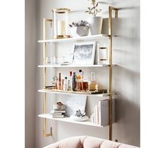 a living room filled with lots of furniture next to a wall mounted book shelf on top of a white wall