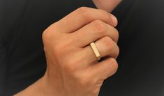 a person wearing a gold ring on their finger