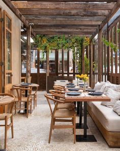 an outdoor dining area with wooden tables and chairs