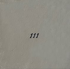 the number 11 is written in black on a stucco wall