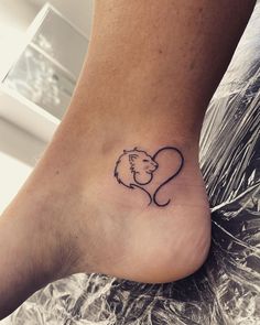 a small tattoo on the foot of a person with a heart and a dog's head