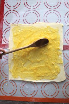 a wooden spoon sitting on top of a piece of food that is being made into dough