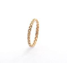 a gold ring that has been made to look like it is braided with rope