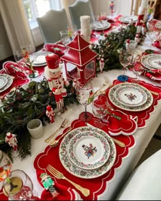 the table is set for christmas dinner with red and white plates