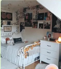 a bed room with a neatly made bed and pictures on the wall