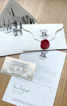 an envelope with a wax stamp on it sitting next to some papers and a postcard