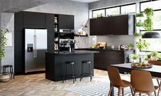 a kitchen with black cabinets and gray counter tops