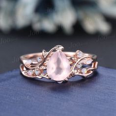 a ring with an oval shaped pink stone surrounded by small crystal stones on top of it