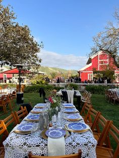 an outdoor table set up with blue and white plates