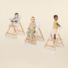 three children sit in high chairs with their mouths open