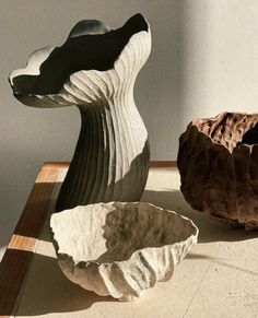 two sculptures sitting on top of a table next to each other