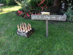 a wooden sign that says put a ring on it next to some wine bottles in the grass