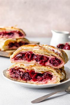 two crepe sandwiches on a white plate with silverware next to the sandwich