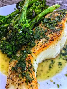 a white plate topped with fish and broccoli