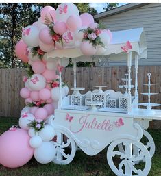 a pink and white cart with balloons attached to it