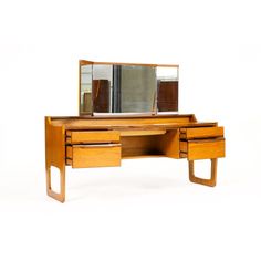 a wooden desk with two drawers and a mirror