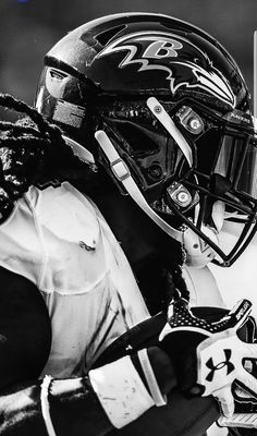 a black and white photo of a football player wearing a helmet with the number 24 on it