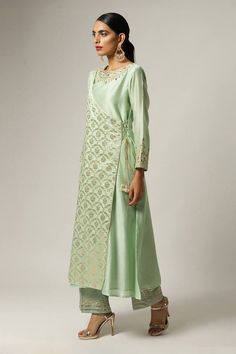 Green overlap kurta with embroidered floral motifs on yoke and sleeves hem. Paired with embroidered hem pant and floral embroidered scallop hem pink dupatta.
Components: 3
Pattern: Embroidered
Type Of Work: Floral
Neckline: Round
Sleeve Type: Full
Fabric: Silk Chanderi
Color: Green
Other Details: 
Scallop dupatta
Semi elasticated pant
Occasion: Puja - Aza Fashions Elegant Straight Kurta Set With Floral Embroidery, Elegant Floral Embroidered Sets With Straight Kurta, Elegant Floral Embroidery Sets With Straight Kurta, Elegant Sets With Floral Embroidery And Straight Kurta, Cotton Silk Kurta With Embroidered Sleeves, Long Sleeve Cotton Silk Kurta With Embroidered Sleeves, Eid Cotton Silk Set With Embroidered Sleeves, Elegant Designer Pant Set With Straight Kurta, Elegant Anarkali Set With Embroidered Border For Spring