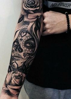 a woman's arm with roses and skulls tattooed on the arm, in black and white