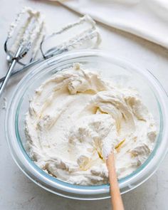 a bowl filled with whipped cream next to a whisk