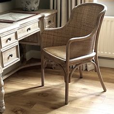 a chair sits in front of a desk with drawers and a potted plant on it