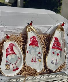 three christmas ornaments in a box on display