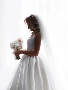 a woman in a wedding dress holding a bouquet