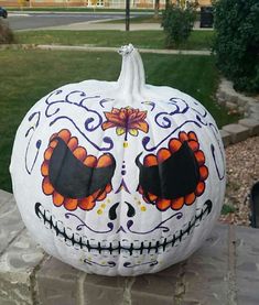 a decorated pumpkin sitting on top of a stone wall