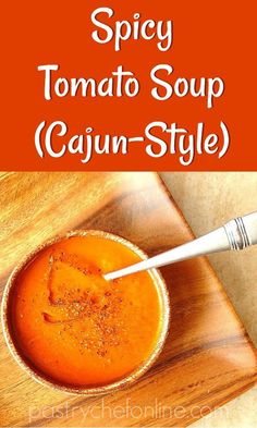 spicy tomato soup cajun - style in a bowl with a spoon on the side