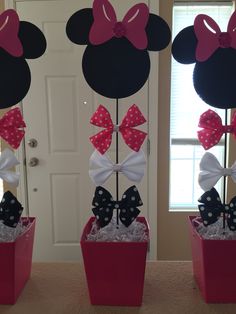 two minnie mouse ears with bows on top of them in red and white boxes next to a door