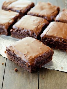 chocolate brownies with frosting sitting on top of each other