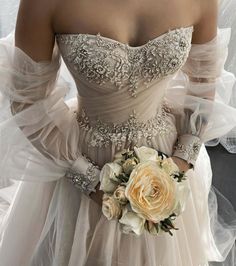 a woman in a wedding dress holding a bridal bouquet