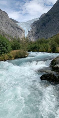 there is a river that has some rocks in it and water running down the side