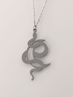 This Crescent Moon Snake Necklace is the perfect way to show your unique style. Featuring a crescent moon and serpent design, this striking piece of occult jewelry will make the perfect statement. Add a hint of mystery and allure to your look with this gorgeous crescent moon snake necklace. You'll feel confident and powerful wearing this one of a kind piece of jewelry. With its unique and intricate design, you'll stand out from the crowd and showcase your individual style. Get ready to take your Spiritual Metal Jewelry In Snake Shape, Spiritual Snake-shaped Metal Jewelry, Symbolic Metal Snake Chain Necklace, Symbolic Snake Chain Necklace, Engraved Metal Snake-shaped Jewelry, Black Metal Snake-shaped Jewelry, Symbolic Crescent Metal Jewelry, Silver Symbolic Snake-shaped Necklace, Silver Snake Necklace With Symbolic Style