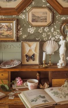 an open book sitting on top of a wooden table next to pictures and other items