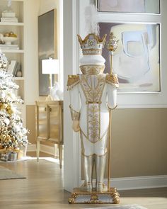 a white and gold statue with a crown on it in front of a christmas tree