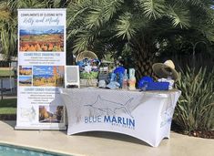 a blue marlin sign next to a pool with palm trees and other items on it