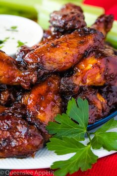 chicken wings covered in bbq sauce and garnished with parsley on a plate