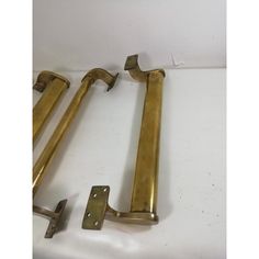 two brass door handles and brackets on a white surface