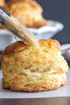 an easy homemade biscuit being dipped with butter