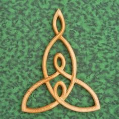 a wooden ornament with two interlocked circles on a green tablecloth