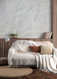 a white couch sitting on top of a hard wood floor next to a wooden table